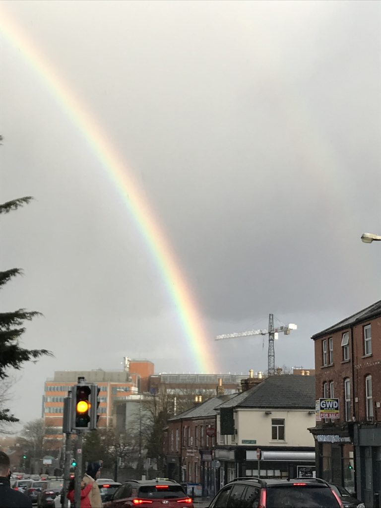 A grey sky with a rainbow, which touches the roof of the Mater hospital, Dublin.